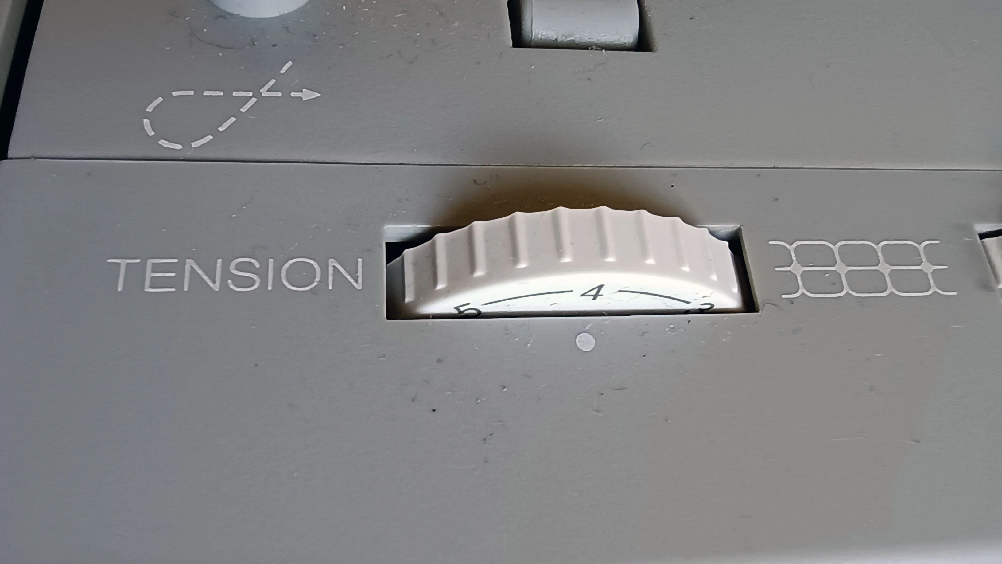 The adjustment dial for thread tension.
