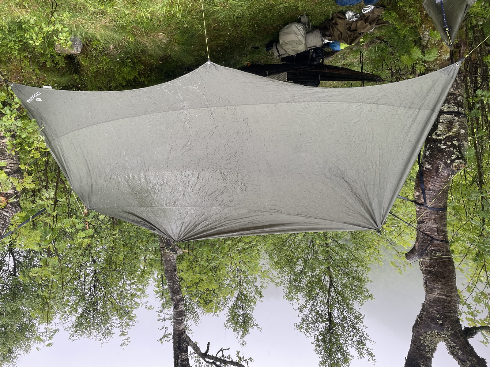 Improvised guy-line attachment point with a stone on the inside of the tarp.