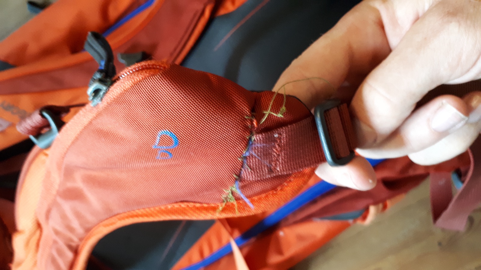 Sewing machine sewing over an opened seam.